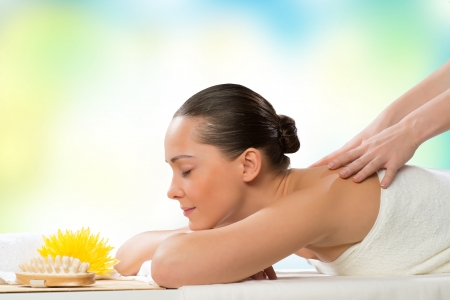 beautiful spa woman lying on the couch, in front of her flower and rolled towelの写真素材