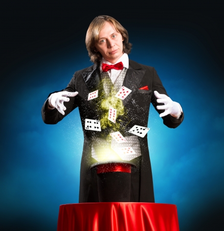 magician casts a spell over the cylinder, around the magic and playing cardsの写真素材