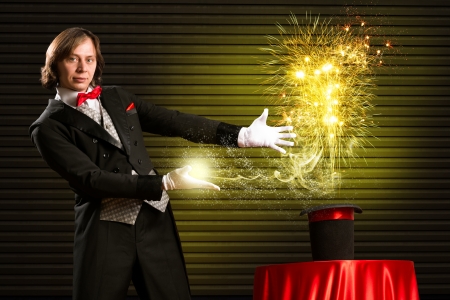 wizard casts a spell over his hat from the hat off smoke, colored lights and magicの写真素材