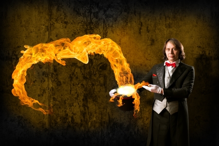 magician conjures a stream of fire out of the hatの写真素材