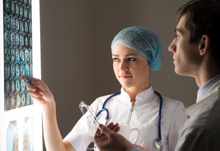 medical colleagues confer near the x-ray image fixed on the glowing screenの写真素材