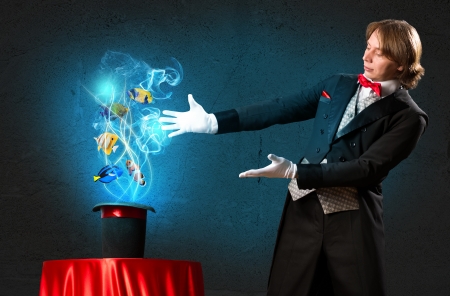 magician casts a spell over the cylinder, circling around the colorful fishの写真素材