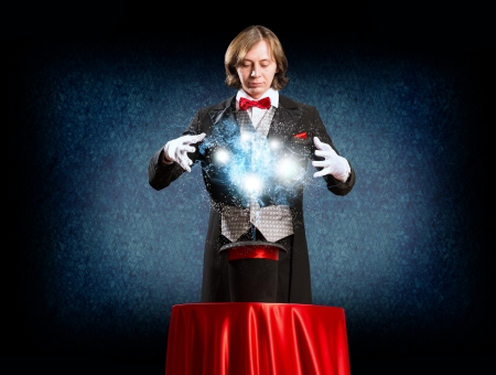 wizard casts a spell over his hat from the hat off smoke, colored lights and magicの写真素材