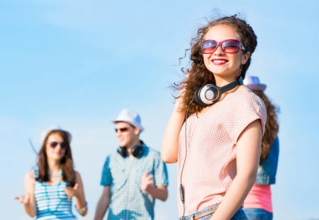 young woman with headphones on a background of blue sky and funny friendsの写真素材