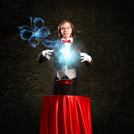 wizard casts a spell over his hat from the hat off smoke, colored lights and magic butterflyの写真素材