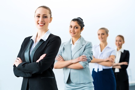 group of business people standing in a row, smiling and crossing his armsの写真素材