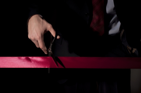 man in a suit, cuts a red tape, opening of eventの写真素材