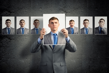 young man holds up a photograph hanging on the wall behind the additional photos with different emotionsの写真素材