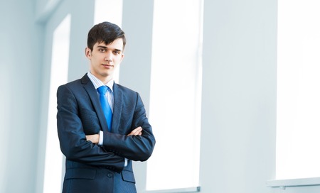 Portrait of a young successful businessman in bright officeの写真素材