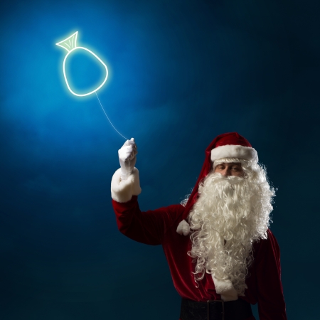 Santa Claus holding a shining light symbol of the Christmas bag for threadの写真素材