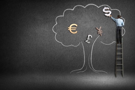 rear view of a businessman on a ladder for the currency to draw a treeの写真素材