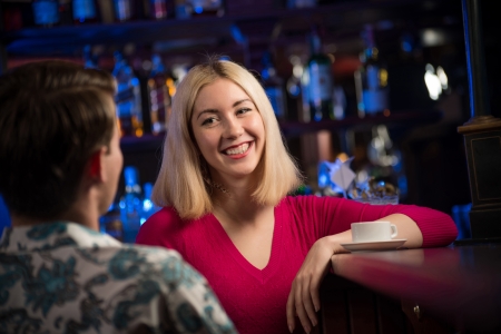 portrait of a nice woman at the bar, talking with a man at the bar dateの写真素材