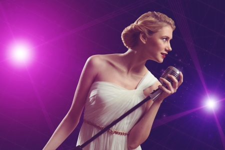attractive female singer with a microphone behind her abstract backgroundの写真素材