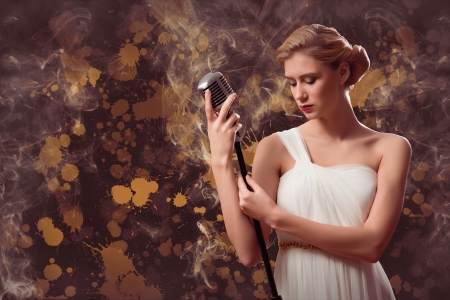 attractive female singer with a microphone behind her abstract backgroundの写真素材