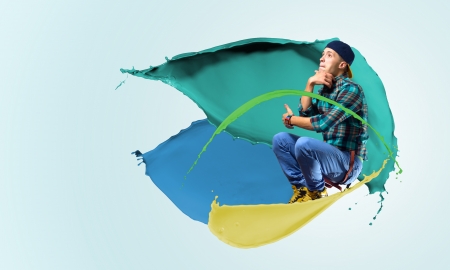 young male dancer jumping surrounded by splashes of paint