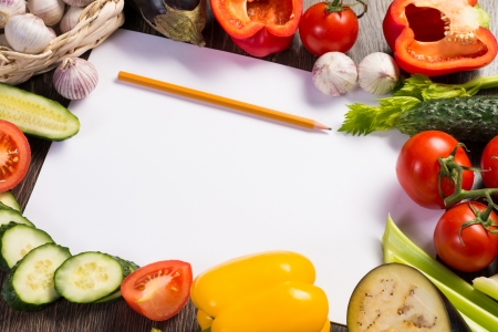 Vegetables tiled around a sheet of paper and a pencil  space for textの写真素材