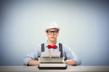 image of a young journalist, sitting at the table for a typewriterの写真素材
