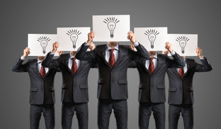 image of a businessmen standing in a row, held in front of a plate with signsの写真素材