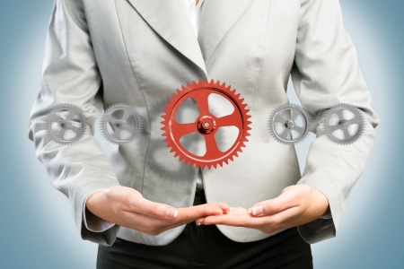 business woman holds up a mechanism of gears, concept of ready solutionsの写真素材