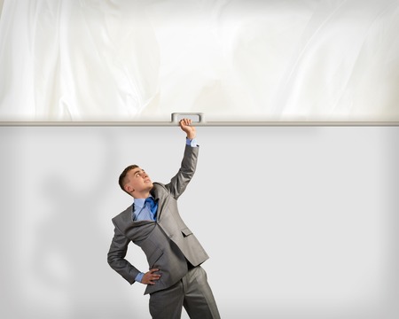 image of a businessman holding a banner with one hand, place for textの写真素材