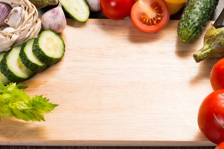 tomatoes, cucumber, garlic, fresh herbs on chopping boardの写真素材