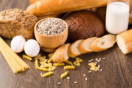 Fresh bread, eggs, pasta, glass of milk and grains  cook fresh bread at homeの写真素材
