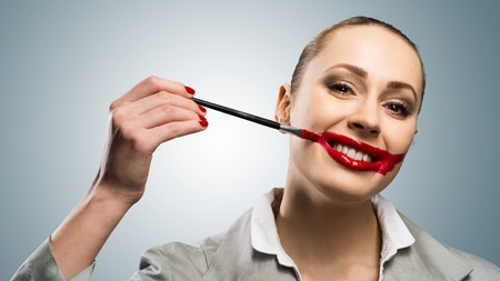 Conceptual image of a young woman with vivid red mouthの写真素材