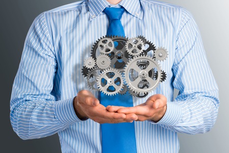 business man holds up a mechanism of gears, concept of ready solutions