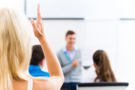 image of a female hand raised in university classroomの写真素材