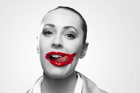 Conceptual black and white image of a young woman with vivid red mouthの写真素材