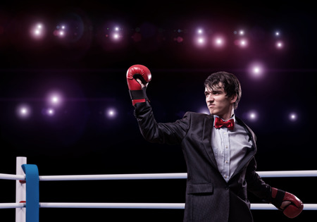 image of a businessman with boxing gloves in the ring, the competition in the businessの写真素材