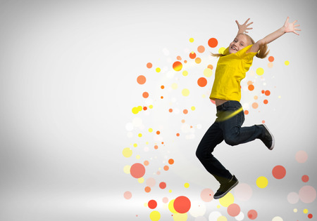 funny girl jumping around colored dots and rays of lightの写真素材