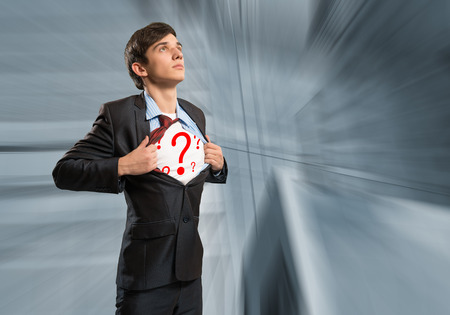 businessman breaks the shirt, under which the question marks behind the abstract backgroundの写真素材
