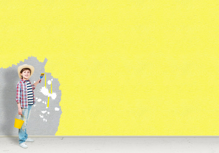image of a boy with hat brush paints the wallの写真素材