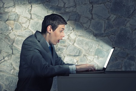 businessman with a laptop, the light on the face from the screenの写真素材
