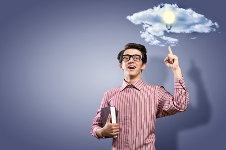 image of a young man holding a book and raised his finger up, creating ideasの写真素材