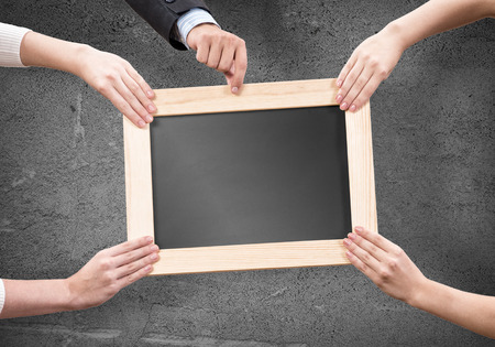 Close up of human hands holding blank wooden frameの写真素材