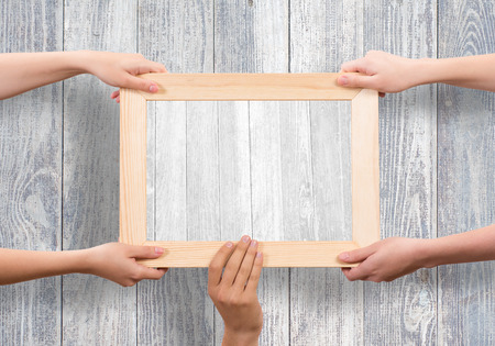 Close up of human hands holding wooden frame