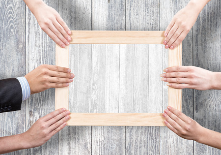 Close up of human hands holding wooden frameの写真素材