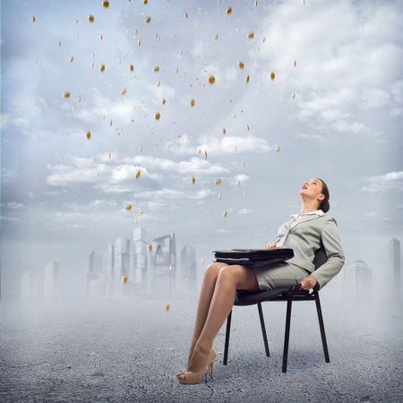 image of a young business woman looking at the falling business signsの写真素材