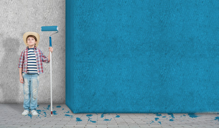 Cute little boy with paint roller in handの写真素材