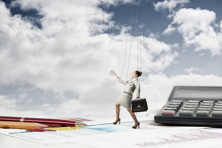 businesswoman puppet doll is on the desk, past the stationery itemsの写真素材