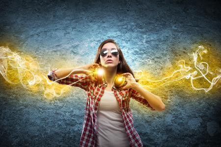 Young teenager girl in shirt wearing headphonesの写真素材