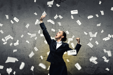 Young aggressive businesswoman screaming in mobile phoneの写真素材