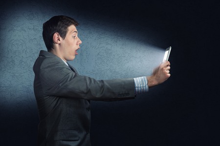 businessman with a tablet computer, the light falls on the face of the screenの写真素材