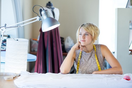 Young blonde needlewoman at studio with tape on neckの写真素材