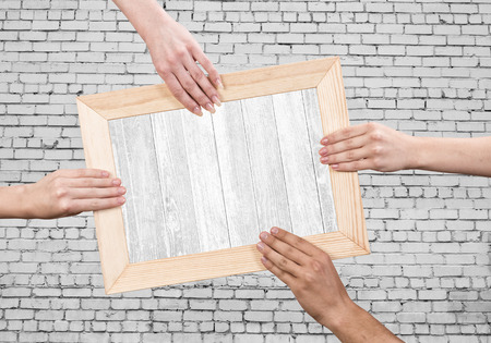 Close up of human hands holding wooden frameの写真素材