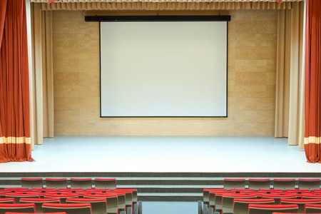 Image of cinema auditorium with blank screen and red seatsの写真素材