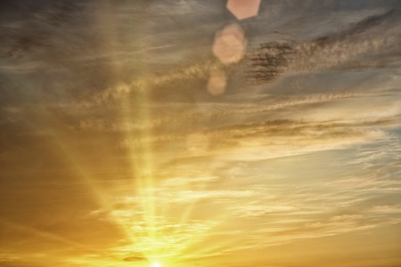 Peaceful warm image of yellow sunset and sunbeamsの写真素材