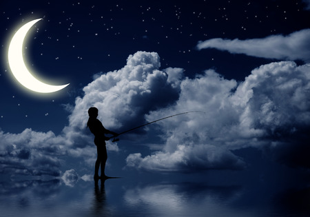 Silhouette of teenager girl fishing at nightの写真素材